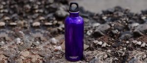 Sealable water bottle suitable for hiking standing on rocky ground