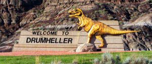 Dinosaur statue next to Drumheller welcome sign